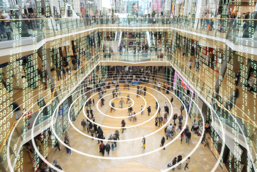 Radio waves spreading out from a mobile phone in a shopping mall with matrix style data layered on top.